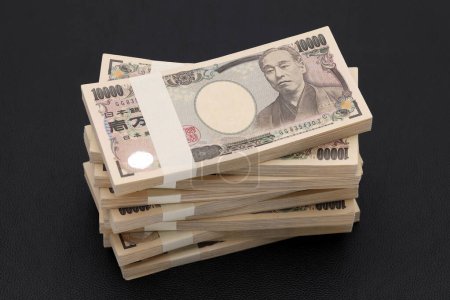 Téléchargez les photos : Une pile de yens japonais. 10 000 yens de billets. Les billets sont écrits "10,000 yen" en japonais. - en image libre de droit