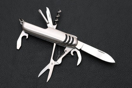 Photo for Close up photo of swiss army knife on black leather background - Royalty Free Image