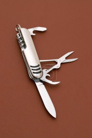 Photo for Close up photo of swiss army knife on brown leather background - Royalty Free Image