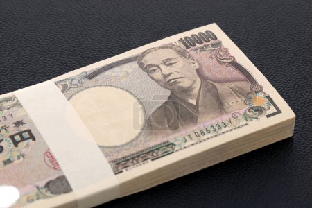 Photo for Japanese yen. 10,000 yen bundle of bills. The banknotes are written as "10,000 yen" in Japanese. - Royalty Free Image