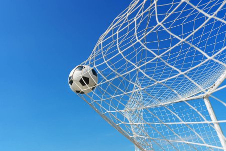  Fußball im Fußballtornetz in einem großen Stadion isoliert bei blauem Himmel. Fußballnetz.