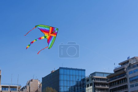 Colorful kite soars high in the sky Blue sky. Sports kite festival. Clean Monday in Greece. A flying kite with a wriggling tail. Copyspace