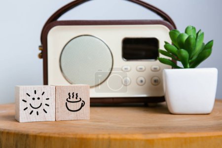 Téléchargez les photos : Imaginez votre matinée parfaite avec ces icônes stimulantes d'humeur sur des blocs de bois, une tasse de café et un soleil radieux, à côté d'une radio nostalgique et d'une plante succulente vibrante. - en image libre de droit