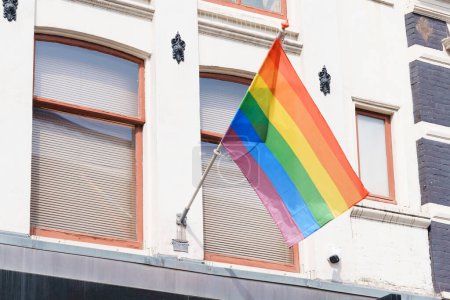 Bandera LGBTQ ondeando orgullosamente en un edificio, colorida bandera