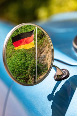Photo for Reflection of the flag of Germany in the rearview mirror of a retro car - Royalty Free Image