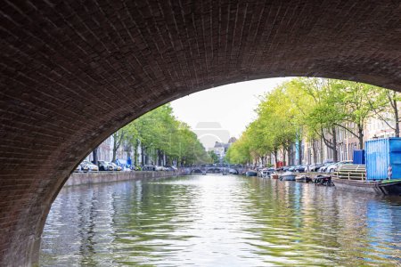 A ship sails under a bridge in Amsterdam, Netherlands