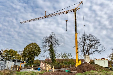 Photo for Construction of new houses in the settlement. A building under construction and a construction crane on the sky background - Royalty Free Image