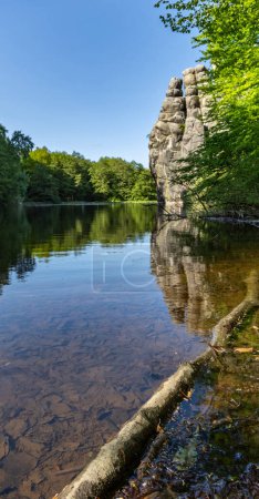 Unique rock formation Externsteine near Detmold, Nordrhein-Westfalen, Teutoburger Wald, Germany, view from the side of the lake