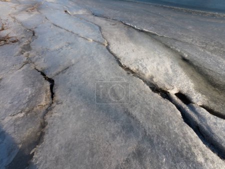 Téléchargez les photos : Glace sur la rivière. marcher sur la rivière gelée. un homme marche sur la neige et la glace. glace dangereuse. l'eau glacée. fissures profondes dans la glace. paysage ensoleillé d'hiver avec une rivière. rivière et soleil d'hiver. - en image libre de droit