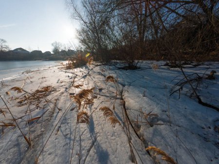 Téléchargez les photos : Glace sur la rivière. marcher sur la rivière gelée. un homme marche sur la neige et la glace. glace dangereuse. l'eau glacée. fissures profondes dans la glace. paysage ensoleillé d'hiver avec une rivière. rivière et soleil d'hiver. - en image libre de droit