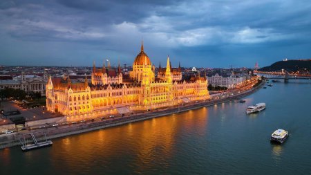 Téléchargez les photos : Illuminé Parlement hongrois avec le fleuve Danube, après le coucher du soleil à Budapest, Hongrie. 4K vue aérienne de drone - en image libre de droit