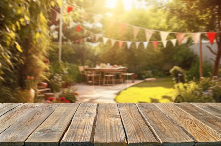 Photo for Empty wooden table with party in backyard, blurred  background - Royalty Free Image