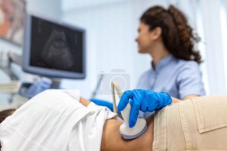 Photo for Doctor conducts ultrasound examination of patientv kidneys. Internal organs ultrasound concept. female's lower back diagnosis carried out with the use of an ultrasound - Royalty Free Image