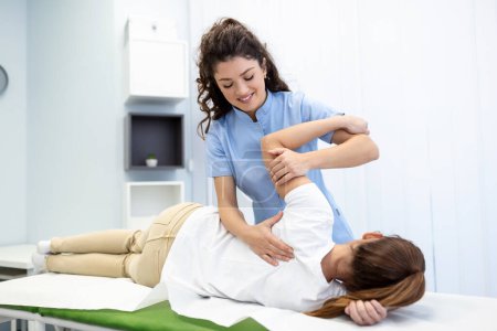 Photo for Physiotherapist treatment patient. Holding patient's hand, shoulder joint treatment. Physical Doctor consulting with patient About Shoulder muscule pain problems Physical therapy diagnosing concept - Royalty Free Image