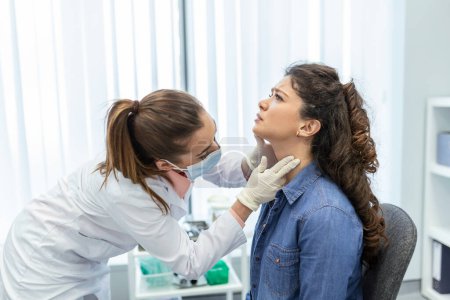 Photo for Medicine, healthcare and medical exam concept - doctor or nurse checking patient's tonsils at hospital. Endocrinologist examining throat of young woman in clinic - Royalty Free Image