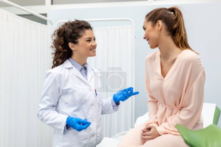Ginecólogo hablando con una paciente joven durante la consulta médica en la clínica moderna. Paciente con ginecólogo durante la consulta en el consultorio ginecológico