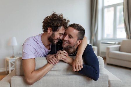 Glückliches schwules Paar, das sich zu Hause auf das Bett legt, sich umarmt und flirtet. Homosexuelle Paare lieben Glücksmomente