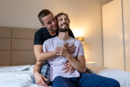 Schwules Paar umarmt sich mit geschlossenen Augen. Zwei junge männliche Liebende berühren sich morgens im Bett. Zärtlich jung gay pärchen bonding bei zuhause.