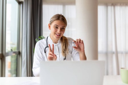 Foto de Doctora que tiene terapia en línea con su paciente, dándoles consejos mientras usa la telemedicina como una nueva normalidad durante el brote pandémico de COVID-19 - Imagen libre de derechos