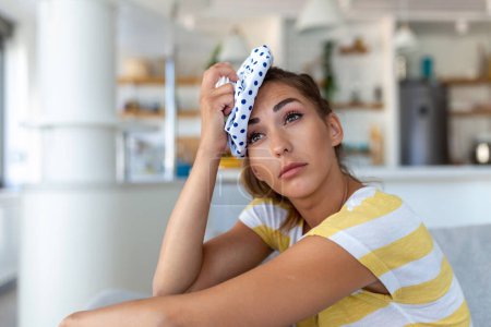 Photo for Close-up shot of a woman suffering from a headache cooling her head with a ice pack - Royalty Free Image