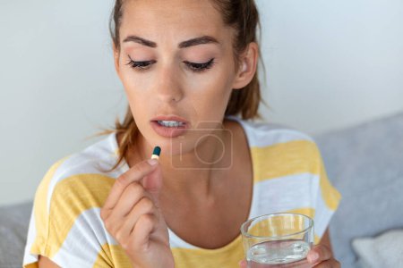 Téléchargez les photos : Femme prend des médicaments avec un verre d'eau. Norme quotidienne de vitamines, médicaments efficaces, pharmacie moderne pour le corps et la santé mentale concept - en image libre de droit