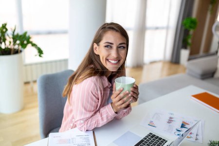 Téléchargez les photos : Les jeunes femmes d'affaires dans le bureau buvant du café et regardant par la fenêtre - en image libre de droit