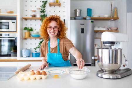 Photo for Baking Concept. Portrait Of Joyful Woman Kneading Dough In Kitchen Interior, Cheerful Female In Apron Having Fun While Preparing Homemade Pastry, - Royalty Free Image