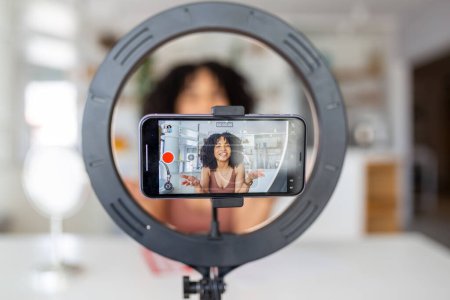 Téléchargez les photos : Jeune influenceuse utilisant son téléphone intelligent pour filmer un message vlog. - en image libre de droit