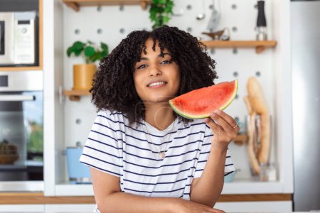 Photo for Pretty young smiling woman eating watermelon, woman holding watermelon slice - Royalty Free Image