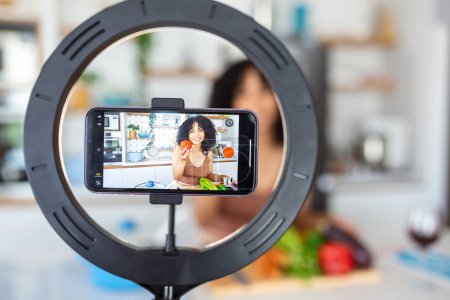 Photo for Vlogging and freelance job concept. food blogger preparing food. cooking and culinary skills concept. Young woman shooting video using camera on tripod. - Royalty Free Image