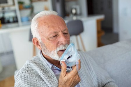 Photo for Sick elderly man making inhalation, medicine is the best medicine. Ill senior man wearing an oxygen mask and undergoing treatment for covid-19. Senior man with an inhaler - Royalty Free Image