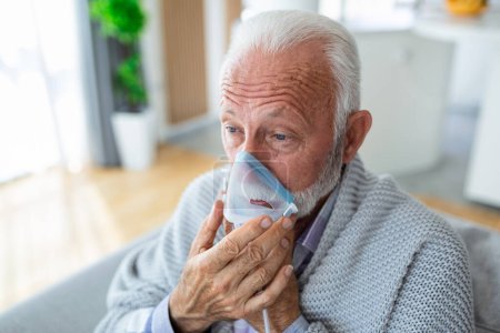 Photo for Sick elderly man making inhalation, medicine is the best medicine. Ill senior man wearing an oxygen mask and undergoing treatment for covid-19. Senior man with an inhaler - Royalty Free Image