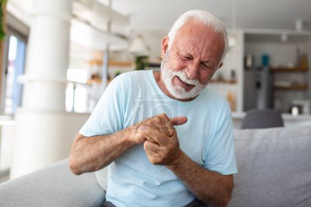 Photo for Elderly man has pain in fingers and hands. Old man with finger pain, Man massaging his arthritic hand and wrist. - Royalty Free Image