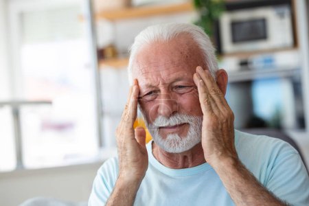 Téléchargez les photos : Mal de tête. Homme âgé souffrant de migraine Douleur Massage Temples assis à la maison. Soins de santé, problèmes de santé chez les personnes âgées Concept - en image libre de droit