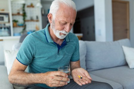 Senior nimmt Tablette mit Glas Wasser in der Hand Gestresster älterer Mann trinkt sedierte Antidepressiva. Der Mann fühlt sich depressiv und nimmt Drogen. Medikamente bei der Arbeit