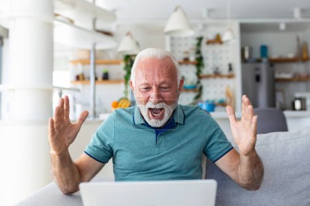 Photo for Elderly man seated on couch looking at laptop screen scream with joy feels excited happy celebrating lottery victory, lucky moment, got online opportunity, sales and discounts e-commerce concept - Royalty Free Image