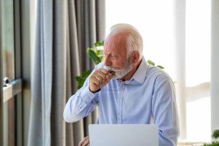 Téléchargez les photos : Homme d'affaires senior se sentant malade avec le froid et la fièvre au bureau, malade avec la grippe assis à son bureau - en image libre de droit