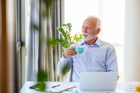 Photo for Shot of a senior financial businessman sitting in his office and drinking a cup of coffee while taking a break. - Royalty Free Image