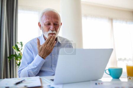 Téléchargez les photos : Homme âgé sur un appel vidéo sur l'ordinateur portable au bureau, envoyer des baisers à la famille à la maison - en image libre de droit