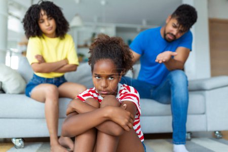 Photo for Naughty Kid. Annoyed Parents Scolding Their Little Daughter For Her Behaviour While Sitting Together On Couch At Home - Royalty Free Image