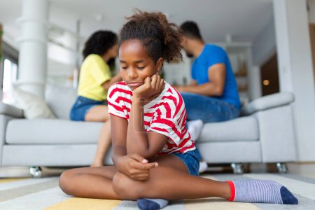 Upset african kid by parents fighting arguing at home, sad stressed little innocent girl suffer from family problems conflicts, unhappy mom dad shouting quarreling divorcing