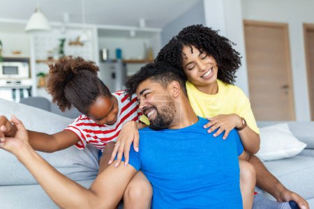 Photo for Positive cheerful multi-ethnic family wife husband child sitting together on couch at home. Close up focus on little daughter and beautiful mother. Happy multiracial family concep - Royalty Free Image