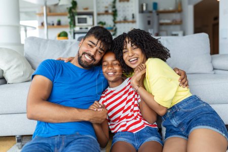 Téléchargez les photos : Heureux famille mère père et enfant fille rire et avoir du plaisir à la maison. Famille afro-américaine heureuse relaxante - en image libre de droit