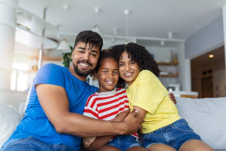Photo for Portrait attractive multi-ethnic wife husband and kid indoors. Close up married couple with little pretty daughter sitting together smiling looking at camera. Concept friendly wellbeing happy family - Royalty Free Image