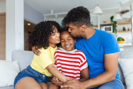 Photo for Cute African American family enjoying time together. happy parents smiling while sitting on sofa with adorable daughter - Royalty Free Image