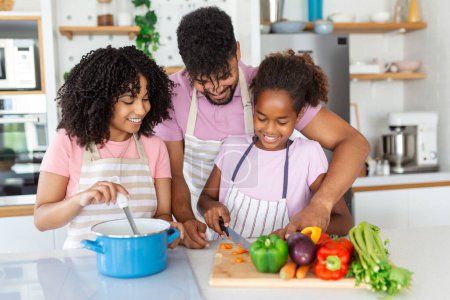 Photo for Family with adorable daughters gathered in modern kitchen cooking together.Enjoy communication and cookery hobby concept. - Royalty Free Image