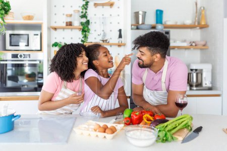 Photo for Happy loving family are preparing bakery together. Mother, father and child daughter girl are cooking cookies and having fun in the kitchen. Homemade food and little helper. - Royalty Free Image
