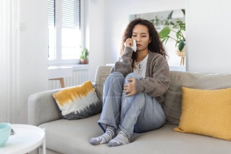 Foto de Unhappy young Asian woman crying alone close up, depressed girl sitting on couch at home, health problem or thinking about bad relationships, break up with boyfriend, divorce - Imagen libre de derechos