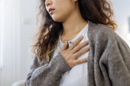 Téléchargez les photos : Stressé jeune femme se sentant douleur et toucher la poitrine souffrent de maladie du cœur à la maison tout en ayant une crise cardiaque, infarctus - en image libre de droit