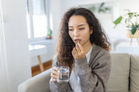 Téléchargez les photos : Asian woman takes medicines with glass of water. Daily norm of vitamins, effective drugs, modern pharmacy for body and mental health concept - en image libre de droit